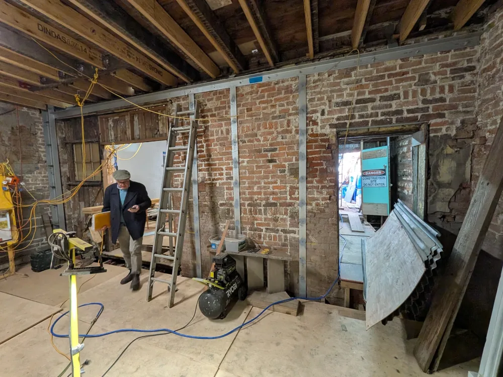 Interior of the building during works with new steel framing installed within the existing brick masonry and timber structure