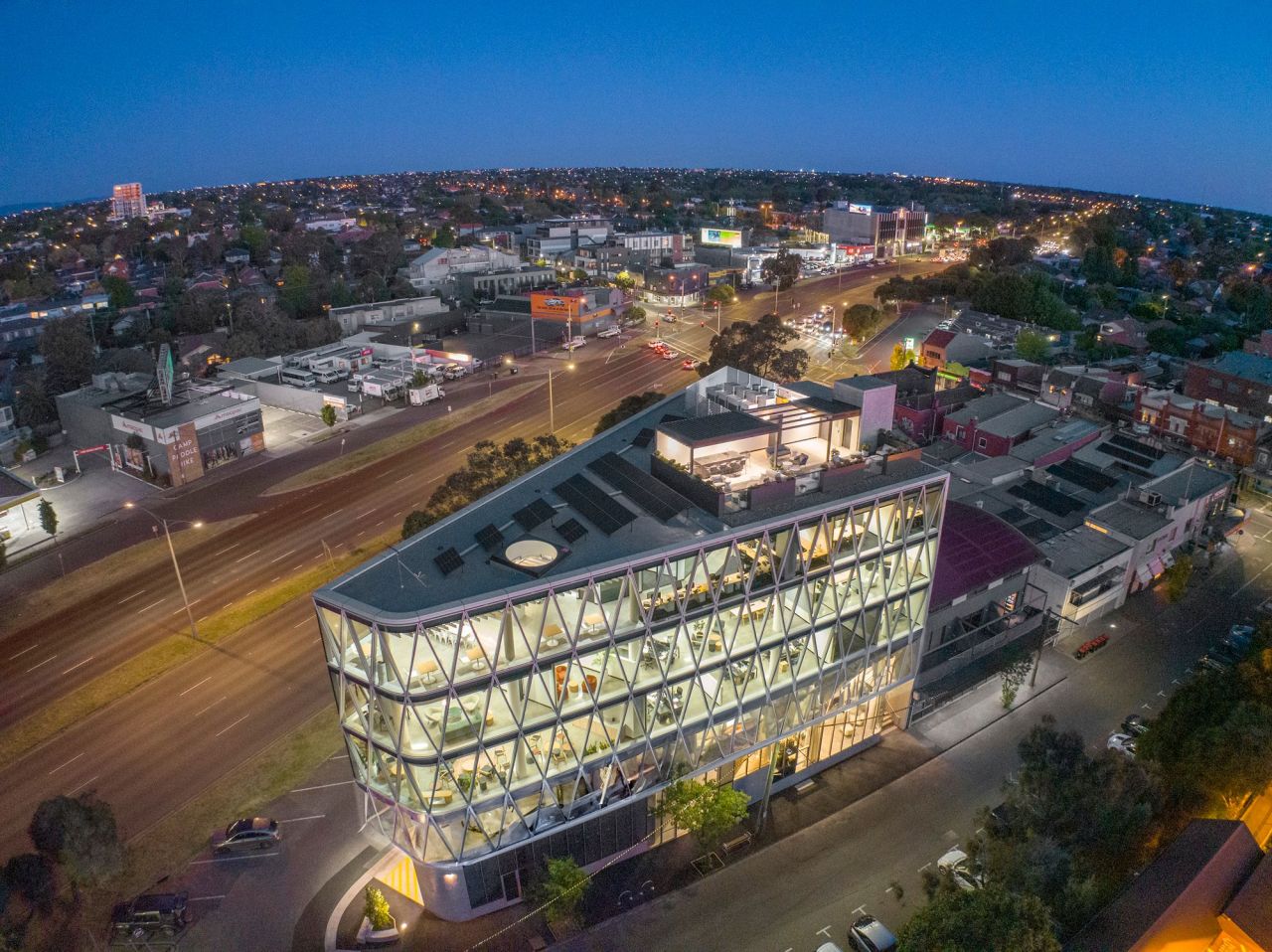 Multi-storey commercial building with exposed diagrid structural facade seen from above