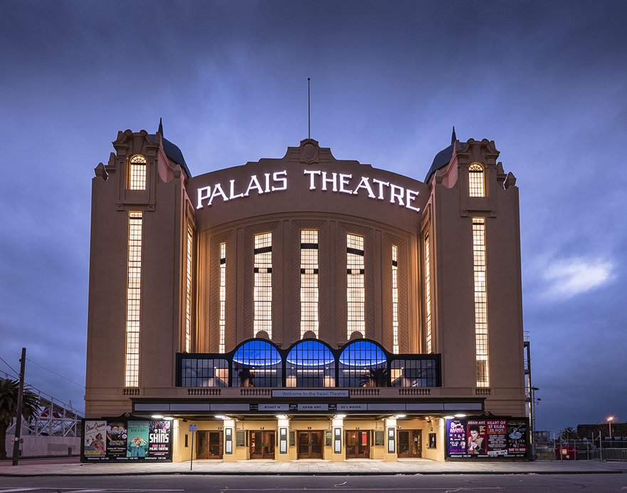 Ornate heritage theatre facade with arched windows and stepped parapet at dusk