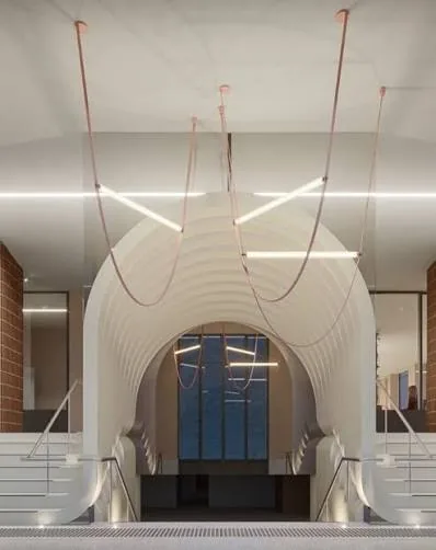 New vaulted arrival space connecting basement and ground floor levels, with stairs descending beneath a curved white ceiling