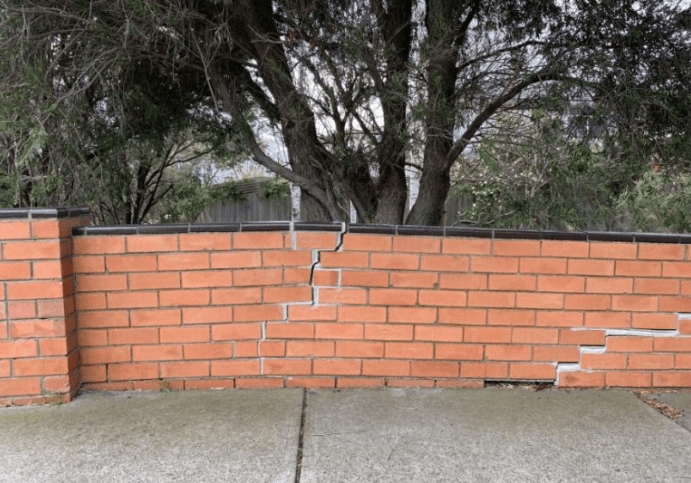 An example of a significantly cracked boundary fence (or garden fence) to the front boundary of a house.