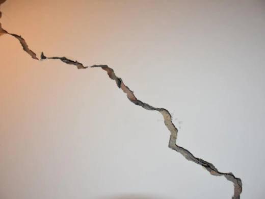 Wide diagonal crack running across an internal wall