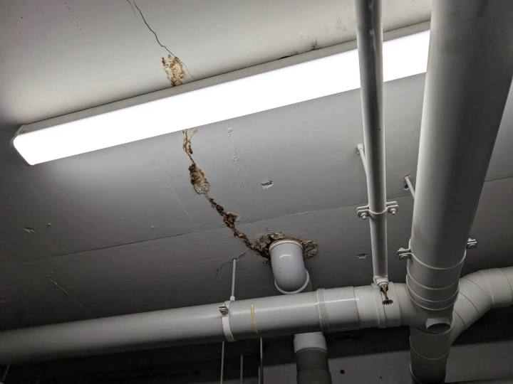 Cracking with leaching and moisture staining across a concrete soffit