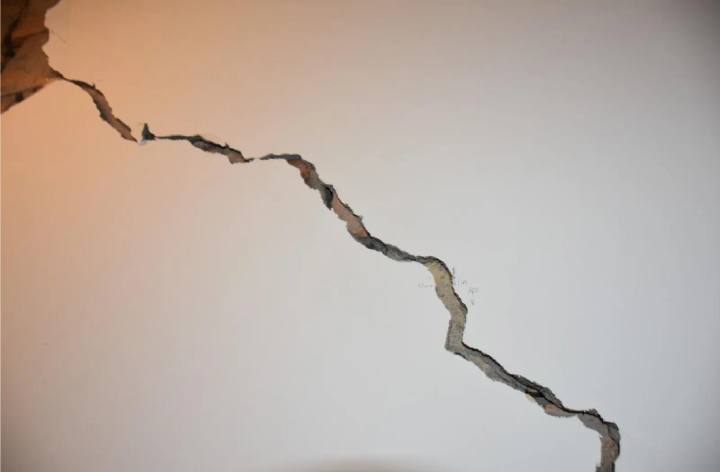 Wide diagonal crack running across an internal wall